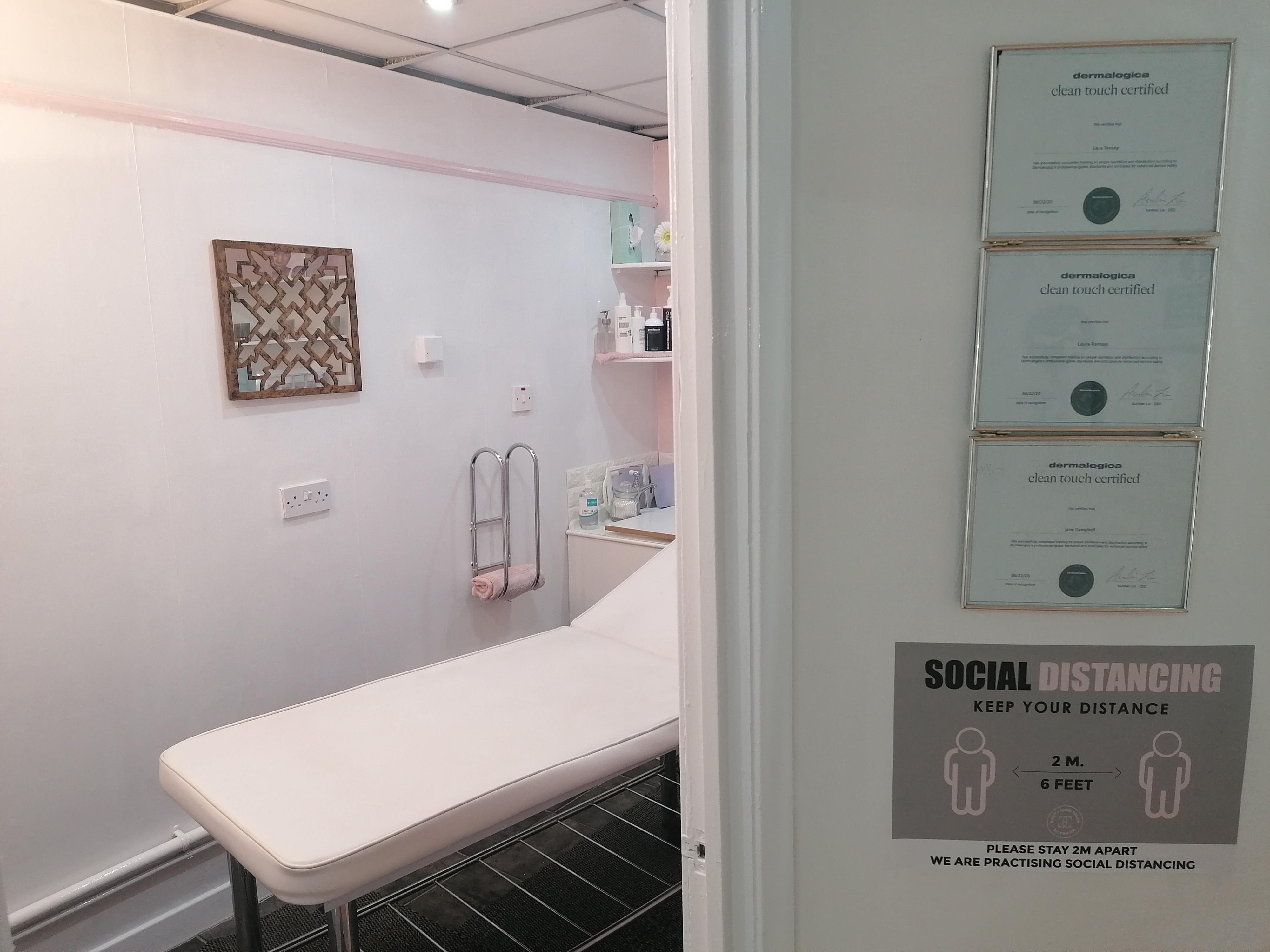 treatment room with bed and social distancing sign